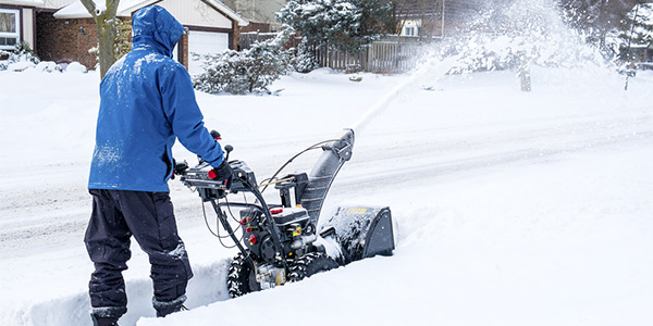 man removing snow with a snow blower